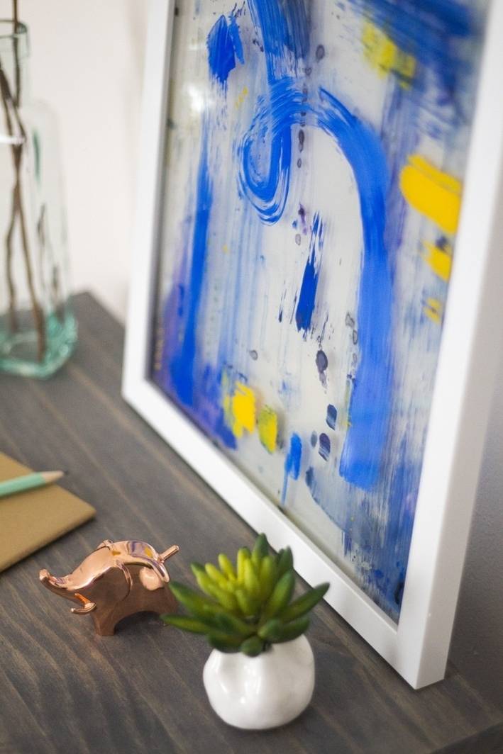 painted in blue frame with decorating artificial flower beside it