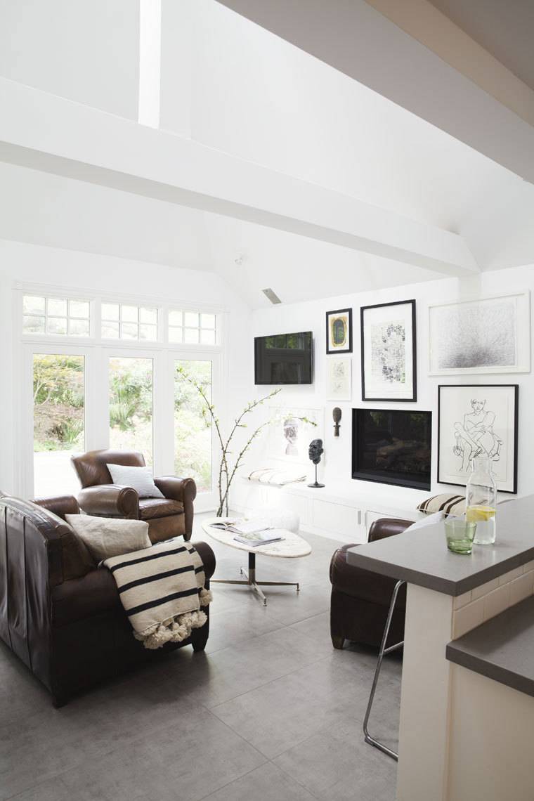 A white room furnished with chairs and pictures.
