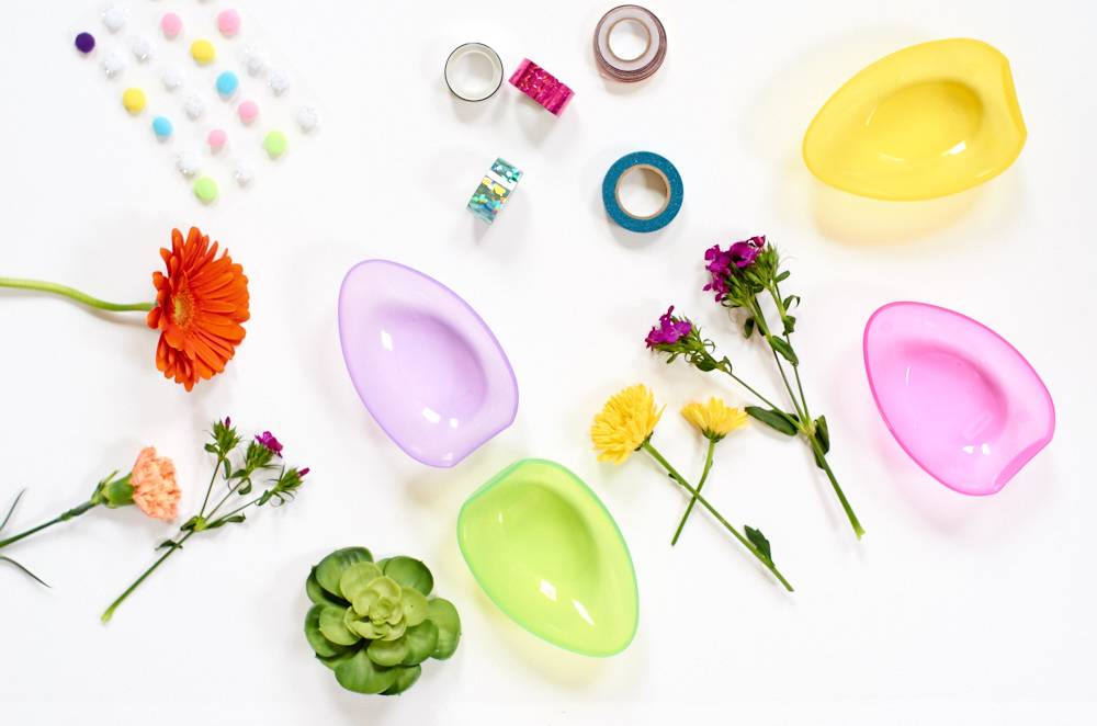 Different molds, flowers and craft supplies spread out on a white surface.