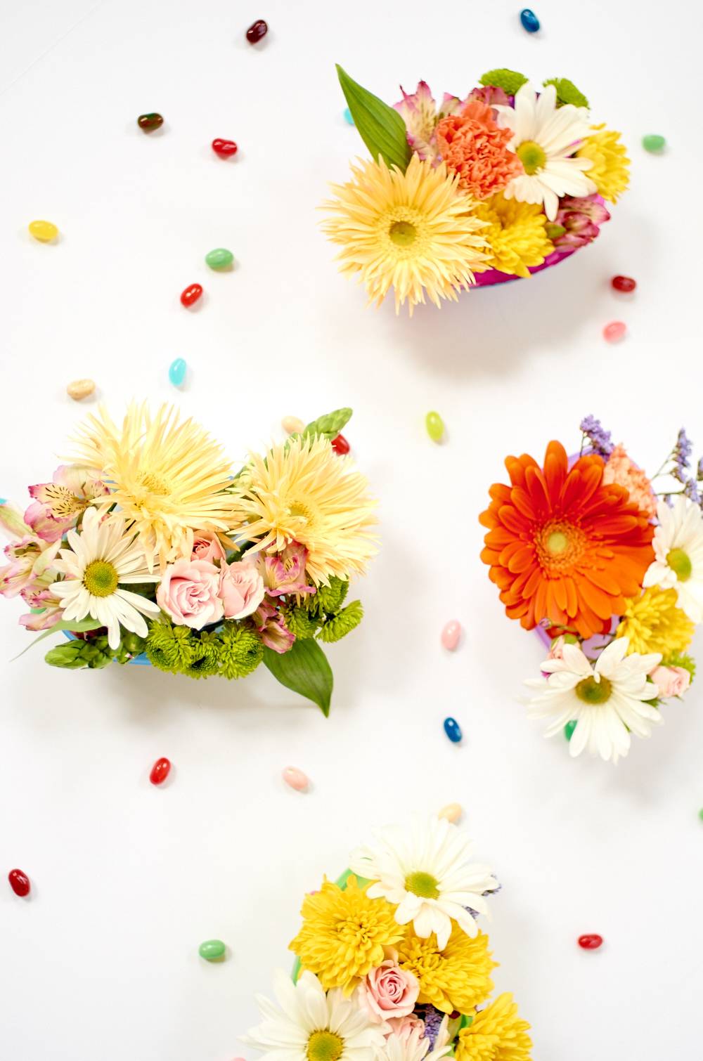 Flowers sit on a white surface with colorful petals.
