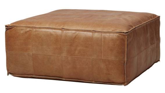 A brown leather rectangular shaped ottoman.