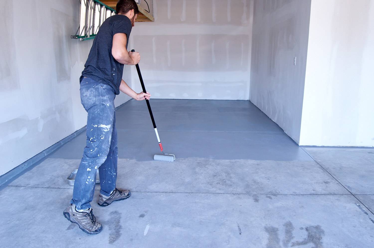 roll the paint on the concrete using a normal paint roller and pole