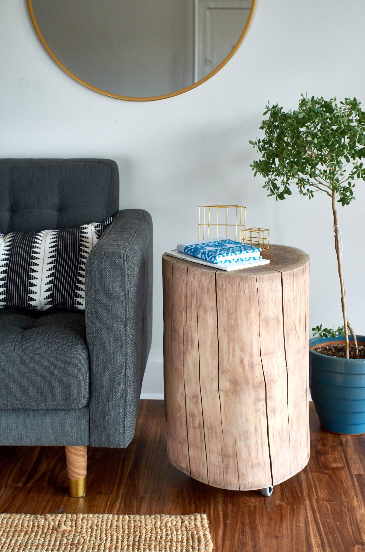 A grey chair with a wooden round side table nearby.