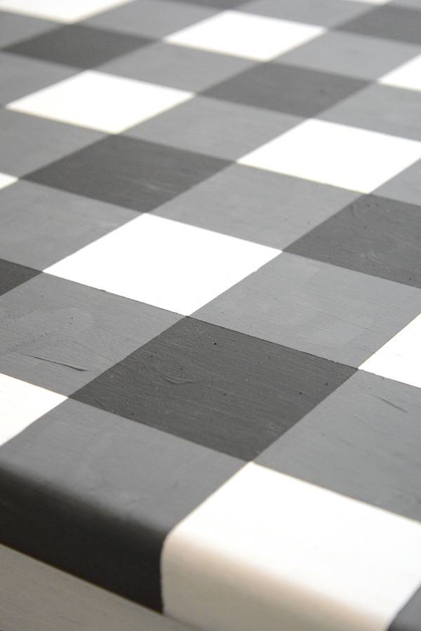 Black, grey and white coloured square type pattern on a bed sheet.