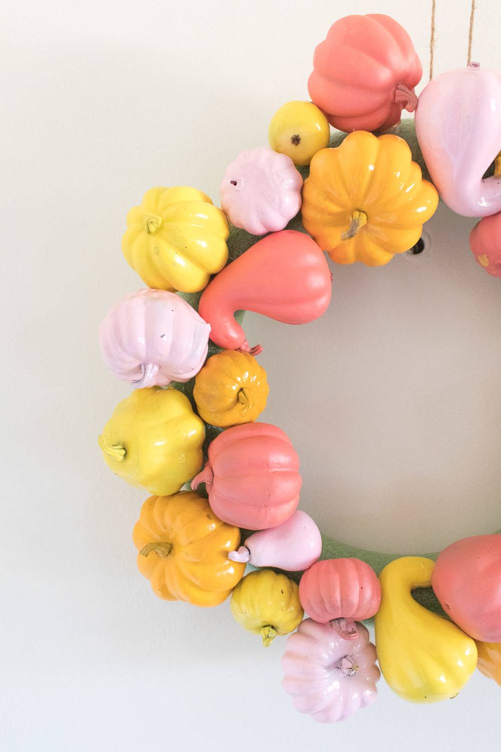 Small wreath made with small painted pumpkins and squash.