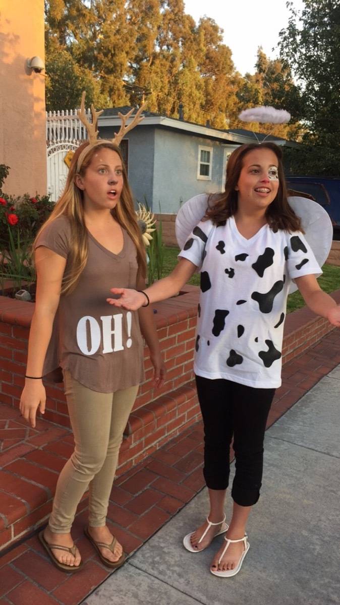 Two women standng together, one with an oh! shirt and one with a shirt that has a cow pattern.