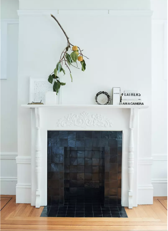 black tiled fireplace with white ornate surround. 