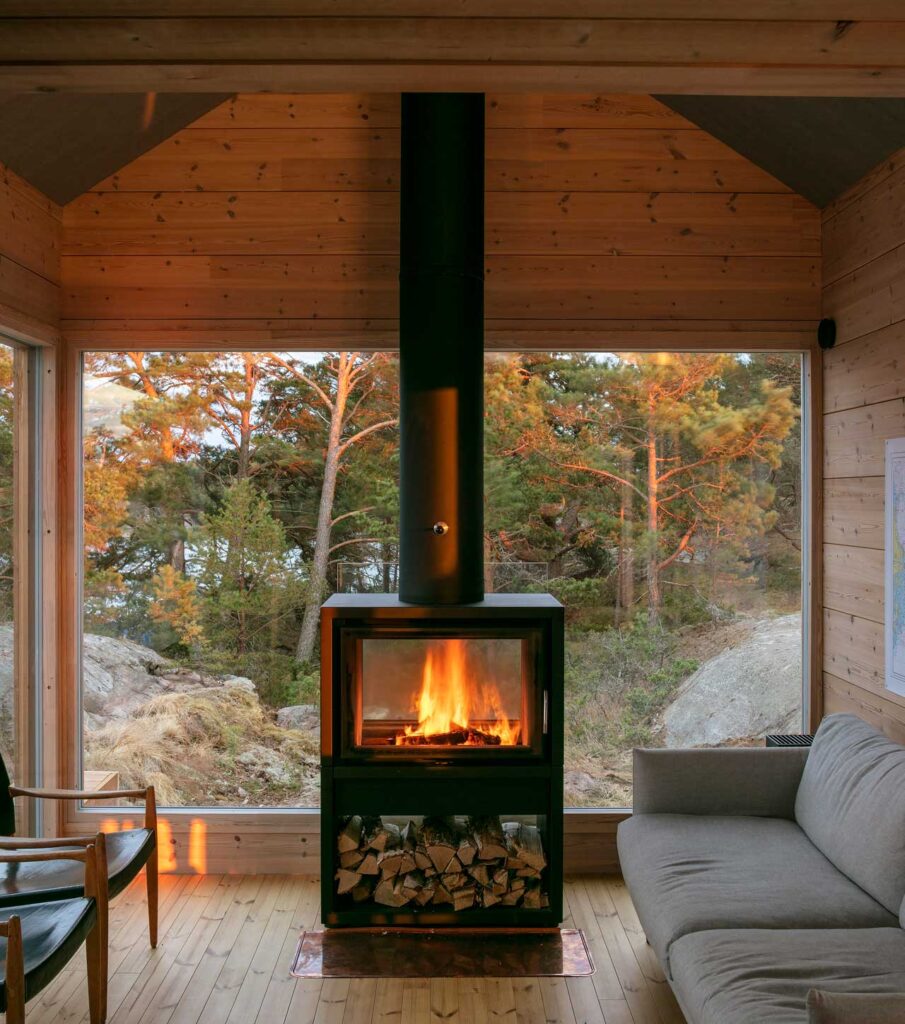 Simple wood-burning stove complements the outdoor views in this modern fireplace idea. 