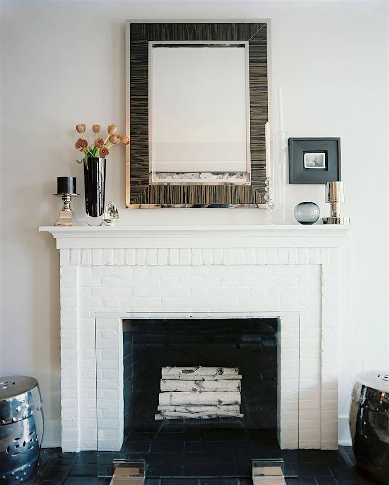 Painted white brick fireplace with a classic white mantel. 