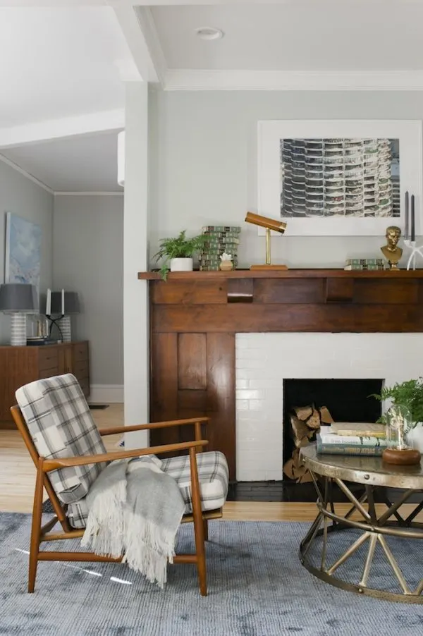 Classic craftsman fireplace with a heavy wood mantel and modern white subway tiles.