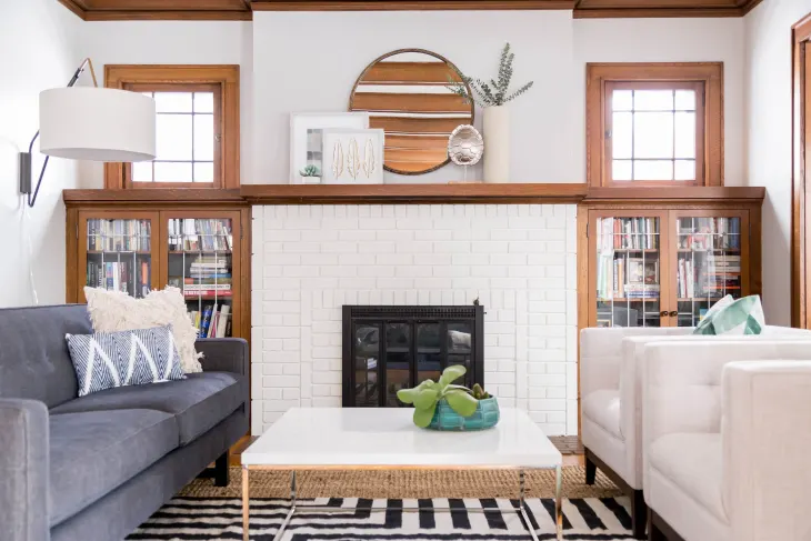This white brick fireplace, surrounded by built-in bookshelves makes a cozy focal point in this room.