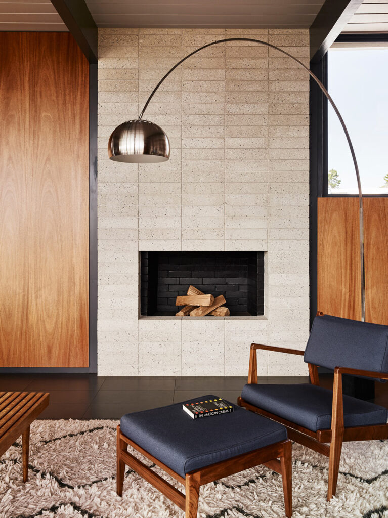 Sleek, mind-century cement brick wood-burning fireplace. Modern fireplace ideas.