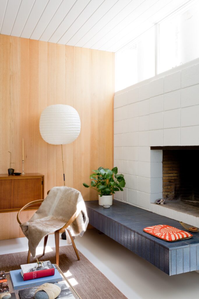 White mid-century brick fireplace with navy blue tile seat. 