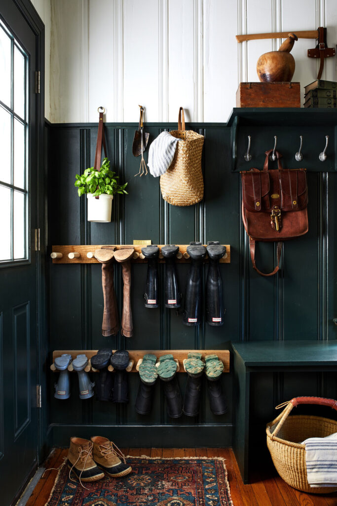 Hooks, dowels, benches, and baskets maximize storage in this mudroom. Image from House 1924.