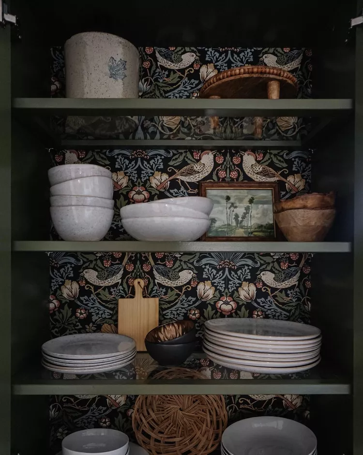 A little cottagecore hidden in the cabinets with this botanical wallpaper backing. Image from Valeria Jacobs. 