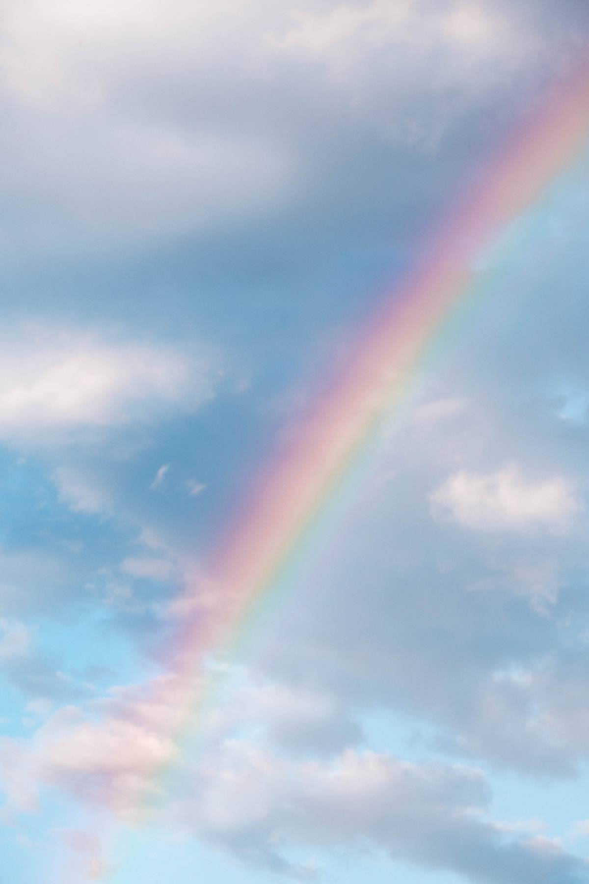 blue sky with white clouds and a rainbow