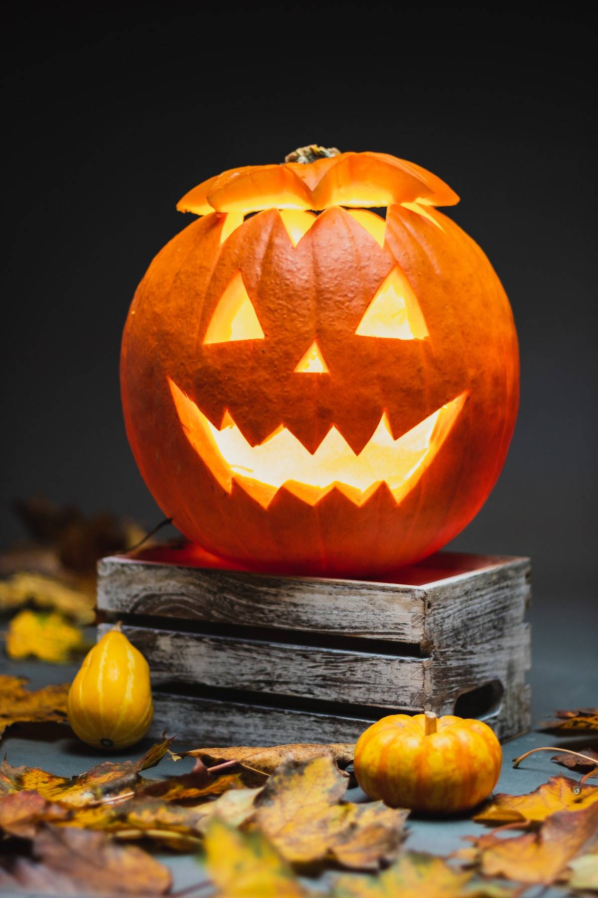 lighted jack o lantern on wooden table with dark background