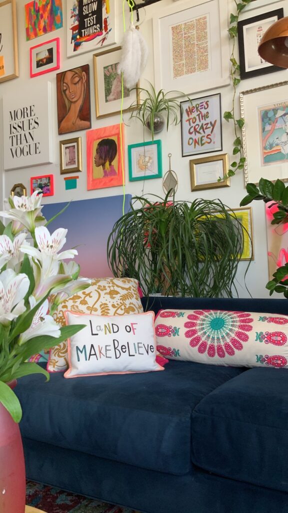 a living room with a blue couch and lots of pictures on the wall