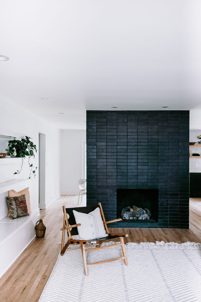 Freestanding dark brick fireplace is the focal point of this living space from the Fireclay blog. Image: Erin Hassett Photography. Similar look could be achieved with black paint.