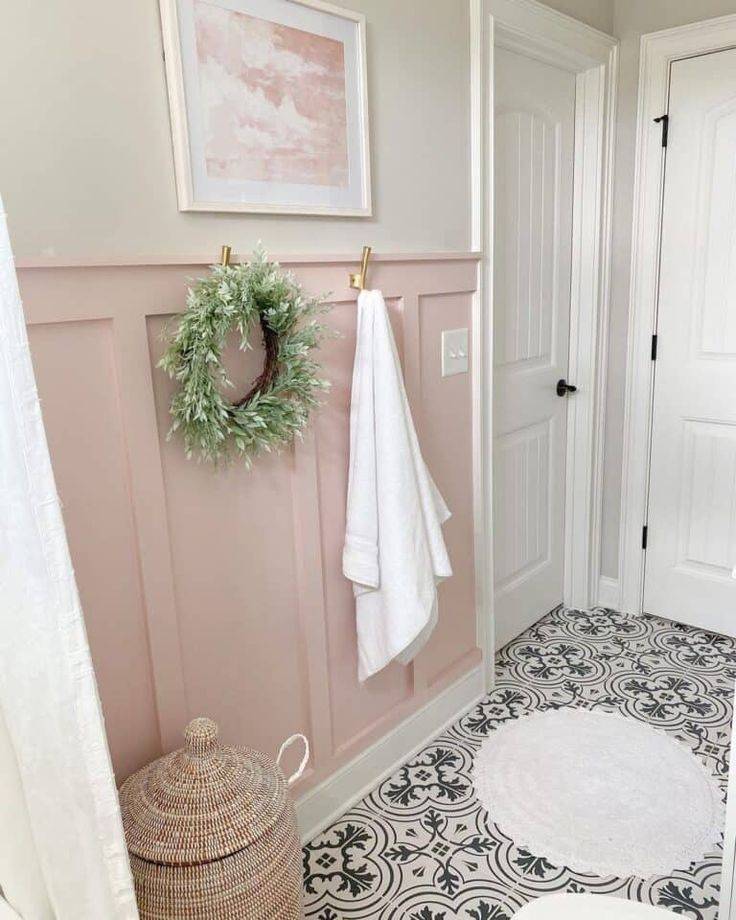 Pink board and batten wall wainscoting with grey tile floor and white round rug.