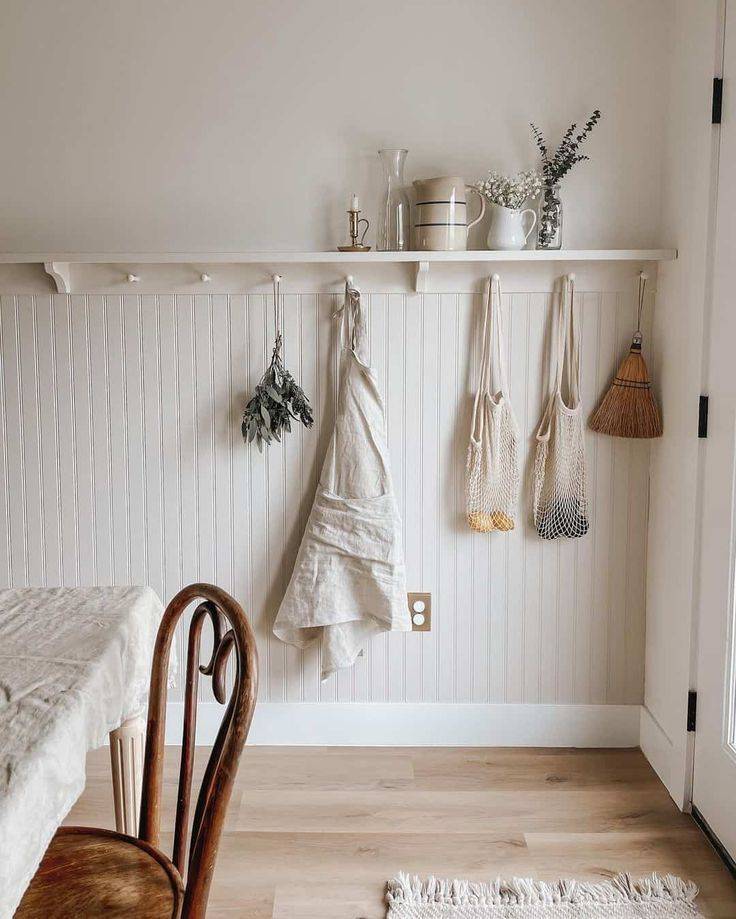 White shelf over beadboard wainscoting with purse and bags hanging