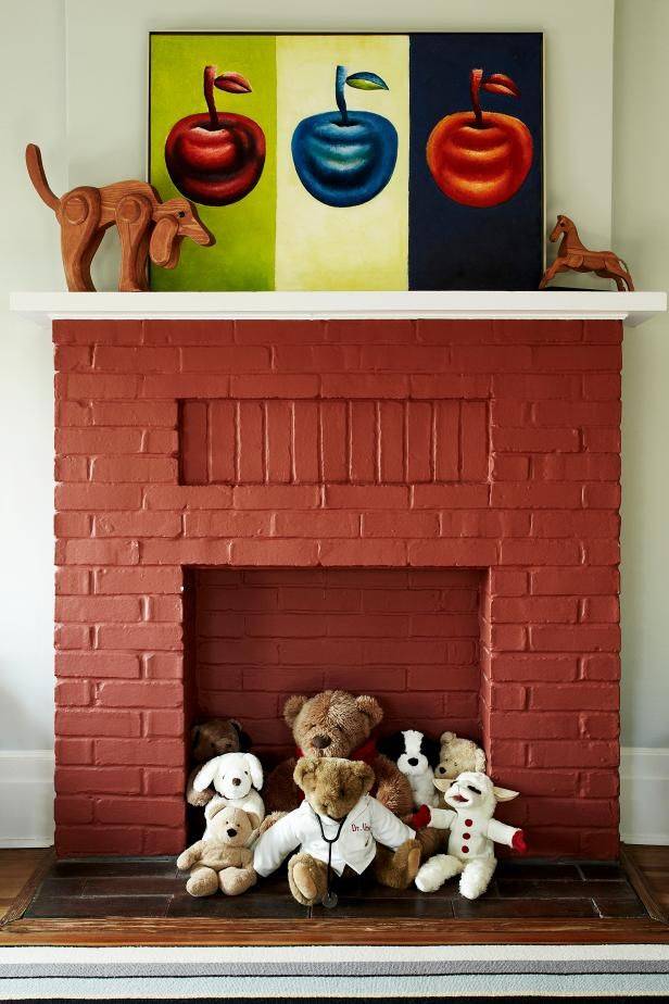 Red fireplace with stuffed animals sitting in front