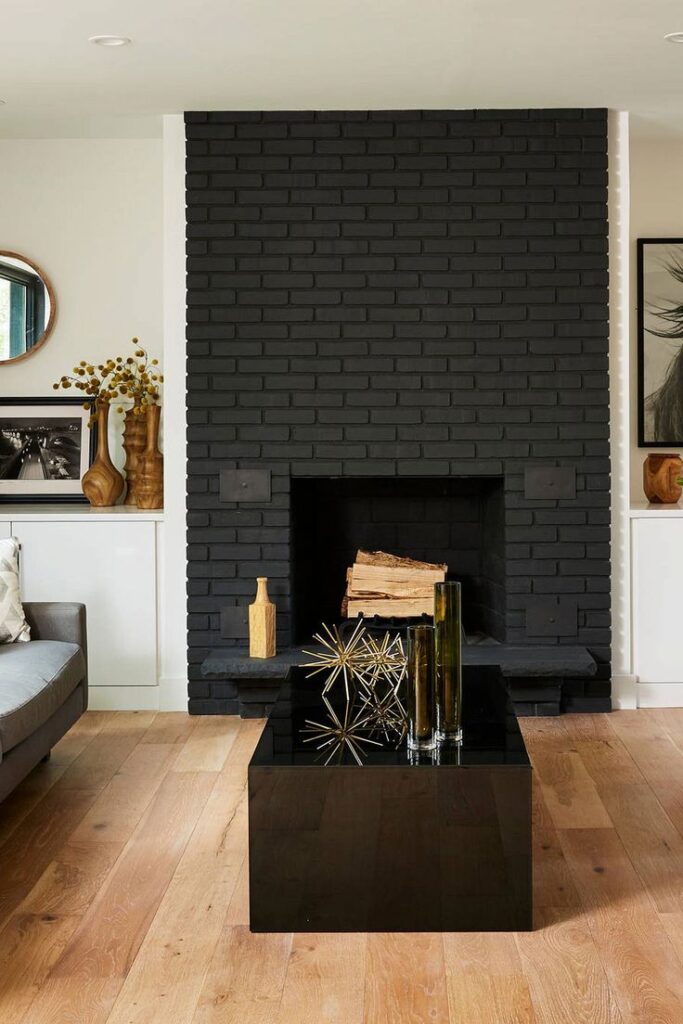 Black brick fireplace in living room behind coffee table