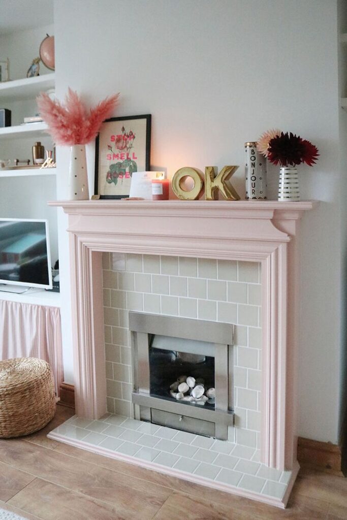 Pastel pink fireplace mantel with white brick