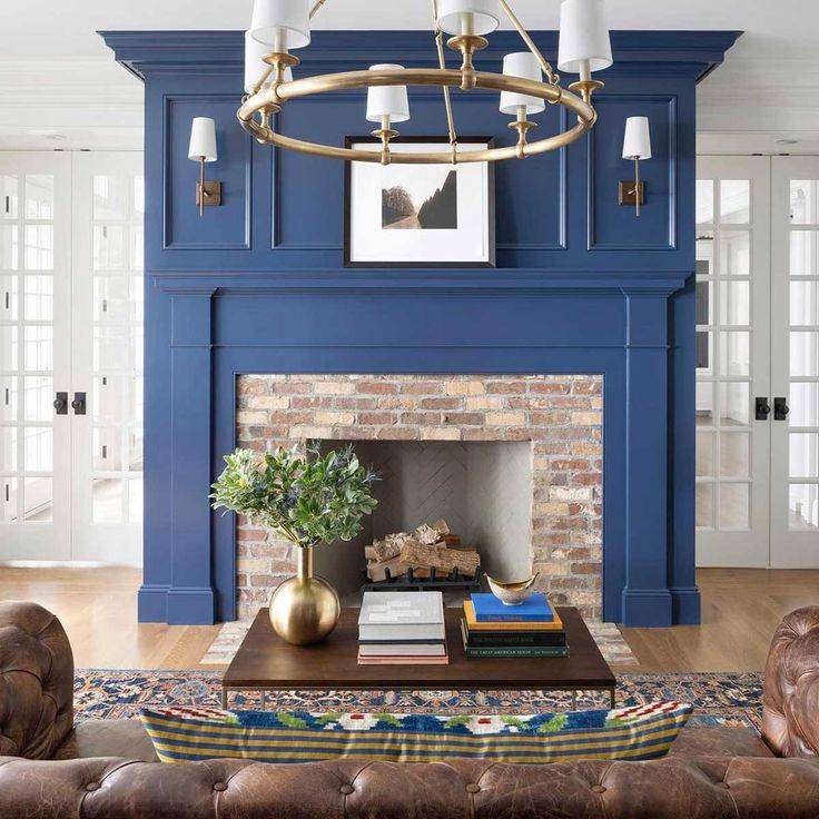 Blue fireplace with beige brick and brown coach, behind brown coffee table