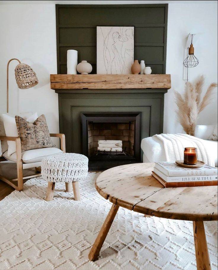 Green fireplace behind cream chair and brown table 