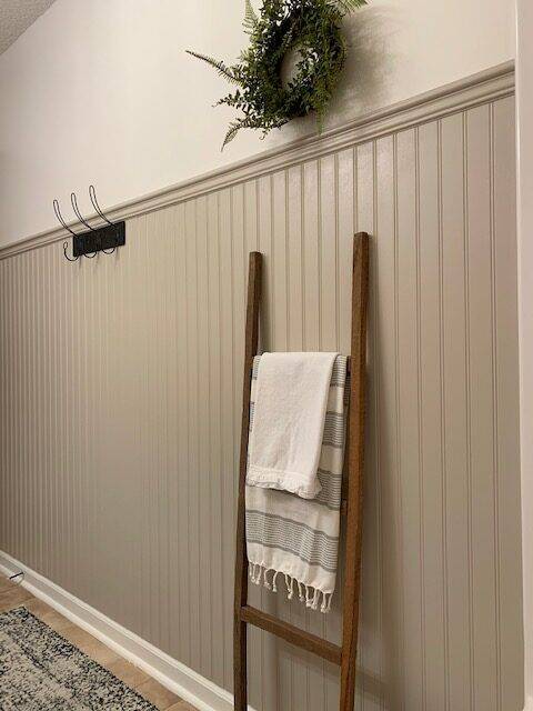Beadboard wall with decorative ladder.