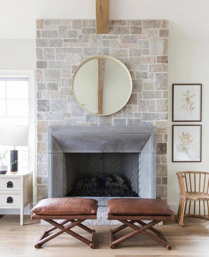 Living room with two brown chairs and gold mirror, gray fireplace