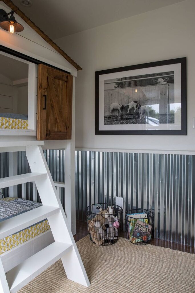Metal wainscoting in room with white stairs and black and white wall art.