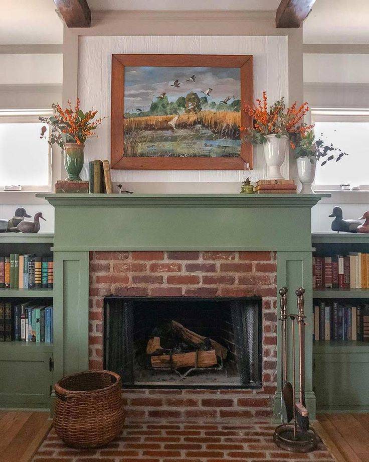 Green and red brick craftsman fireplace with a painting on the wall in living room space