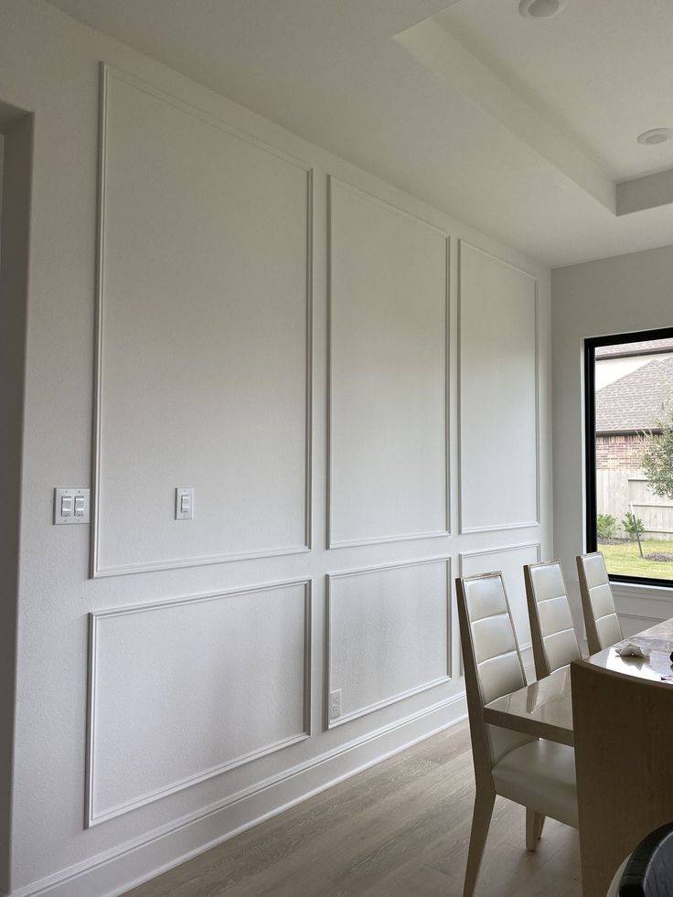 Full wall wainscoting with cream wall, brown dining table and chairs