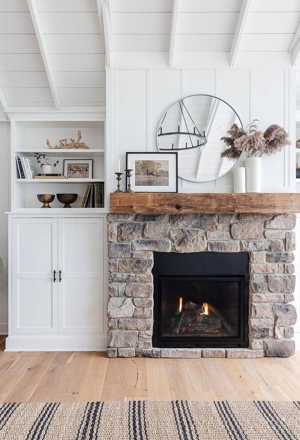 Large brown brick fireplace with mirror and decorative flowers