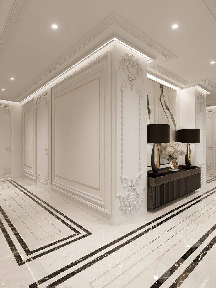 LED and recessed light wainscoting, long rectangular shapes on floor outlined in black and black entry table with two black lamps.