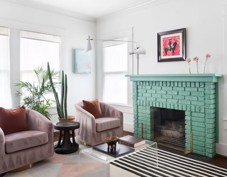 Painted brick fireplace in living room with two lounge chiars 