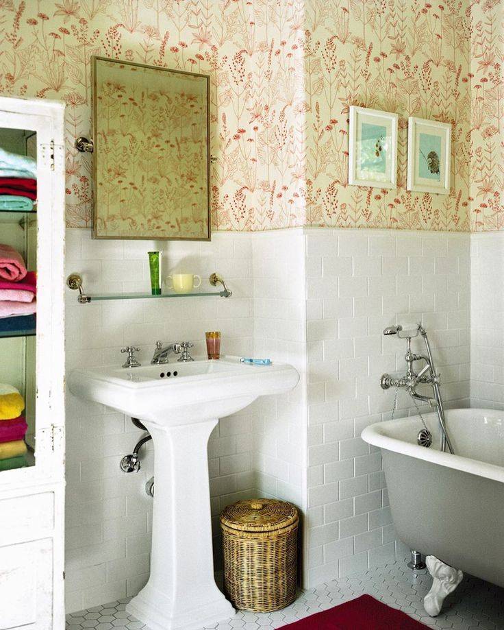 Tiled wainscoting in white with orange wallpaper in small bathroom