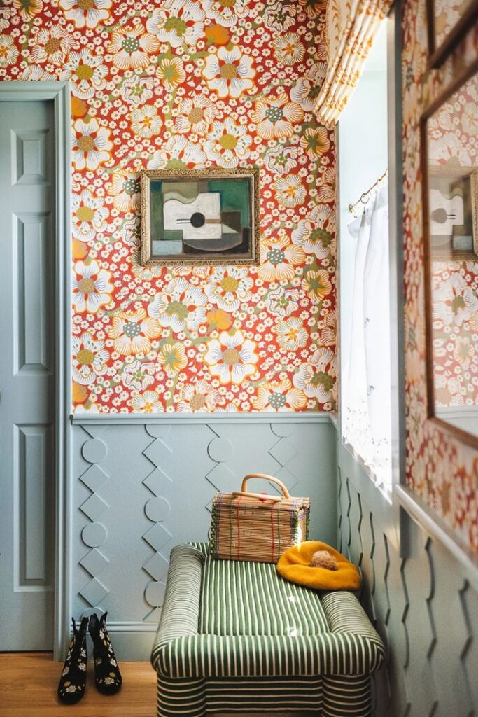 Blue wainscoting against wall with floral wallpaper in bathroom