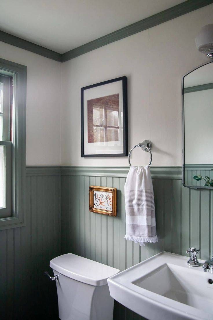 Green classic beadboard wainscoting and cream walls in bathroom