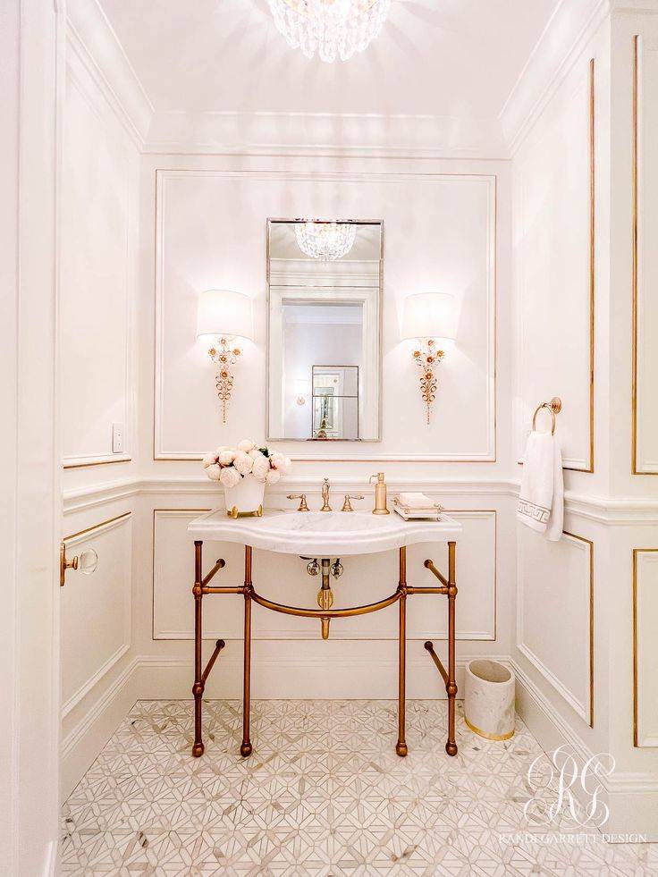 Bathroom with gold and white sink and white wainscoting with gold trim