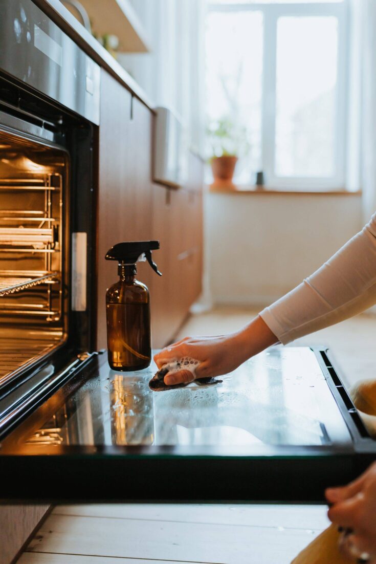 Hand cleaning an oven door