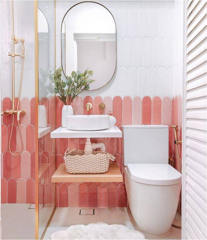 Pink and white wainscoting in bathroom with toilet and sink