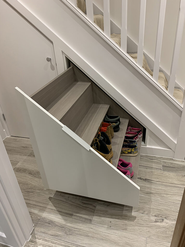 Pull out shoe storage under a stair case. 