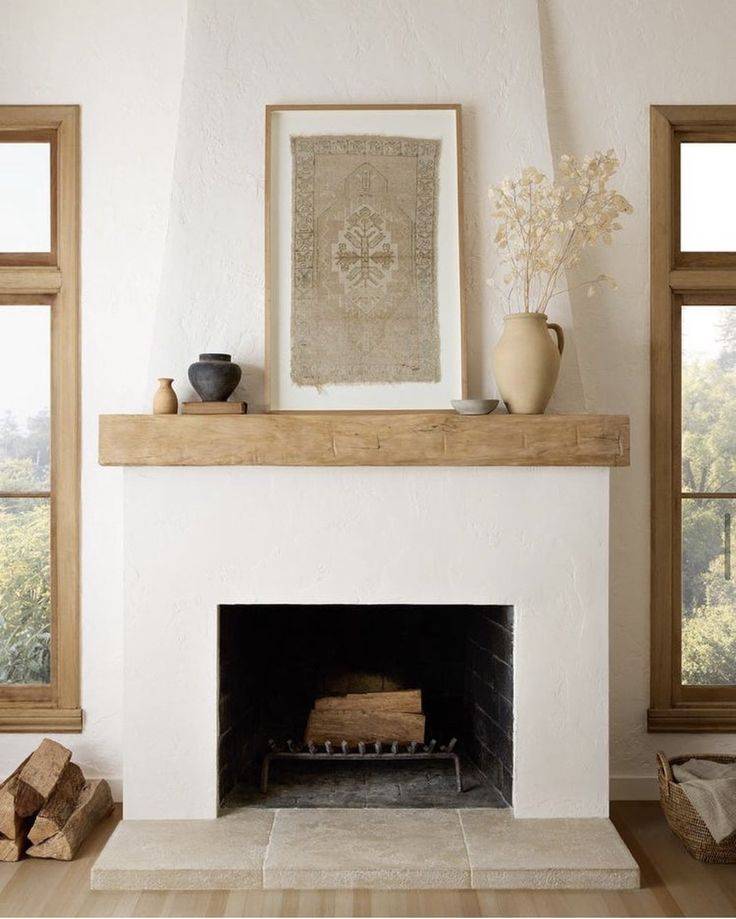 White stucco fireplace with brown mantel and brown and white photo on top