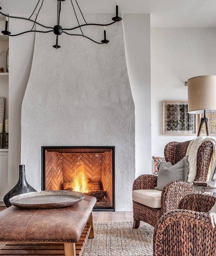 White stucco fireplace with rattan brown chairs 