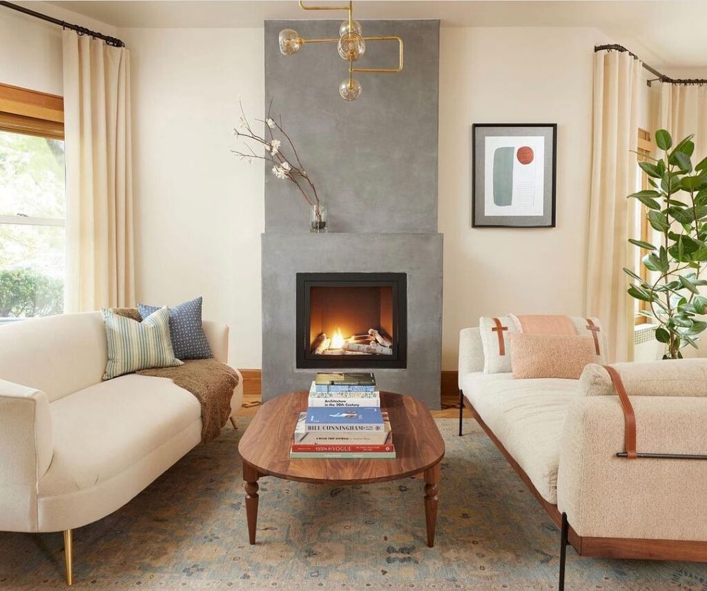Living room with grey stucco wall fireplace and gold metal light fixture 
