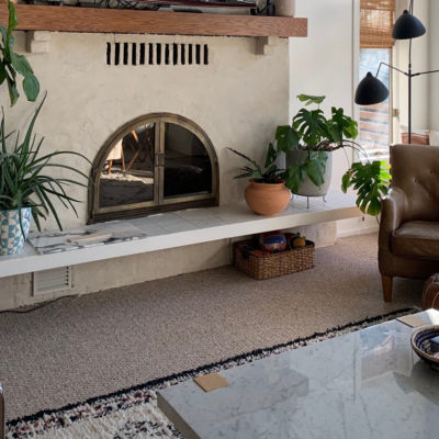 Light beige painted stucco fireplace with plants in living