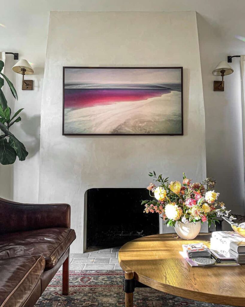 Stucco fireplace with colorful painting in living room